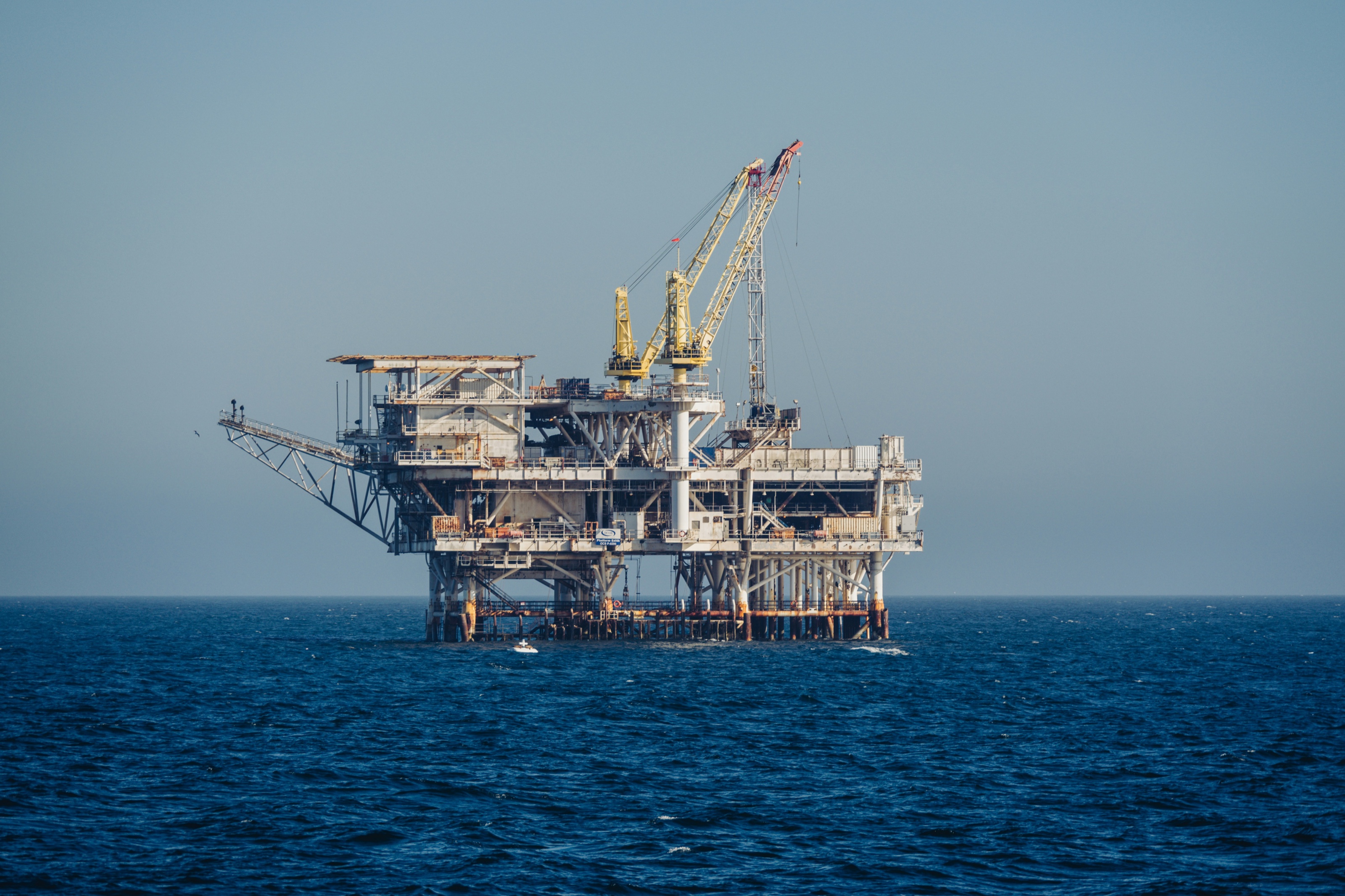 Offshore platform standing in open ocean under a clear sky