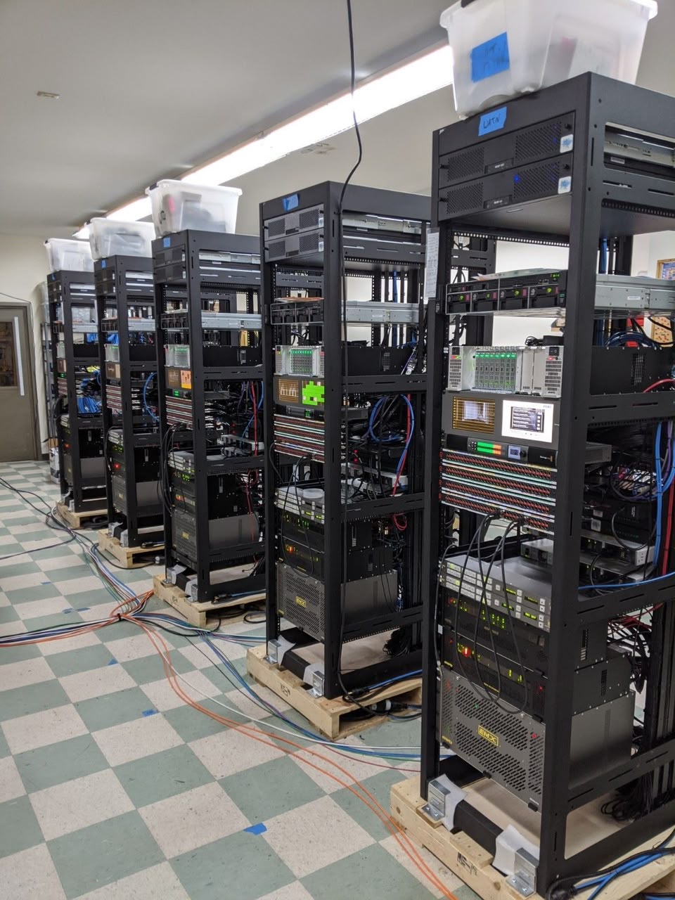 Rows of equipment racks staged on pallets during a facility rollout