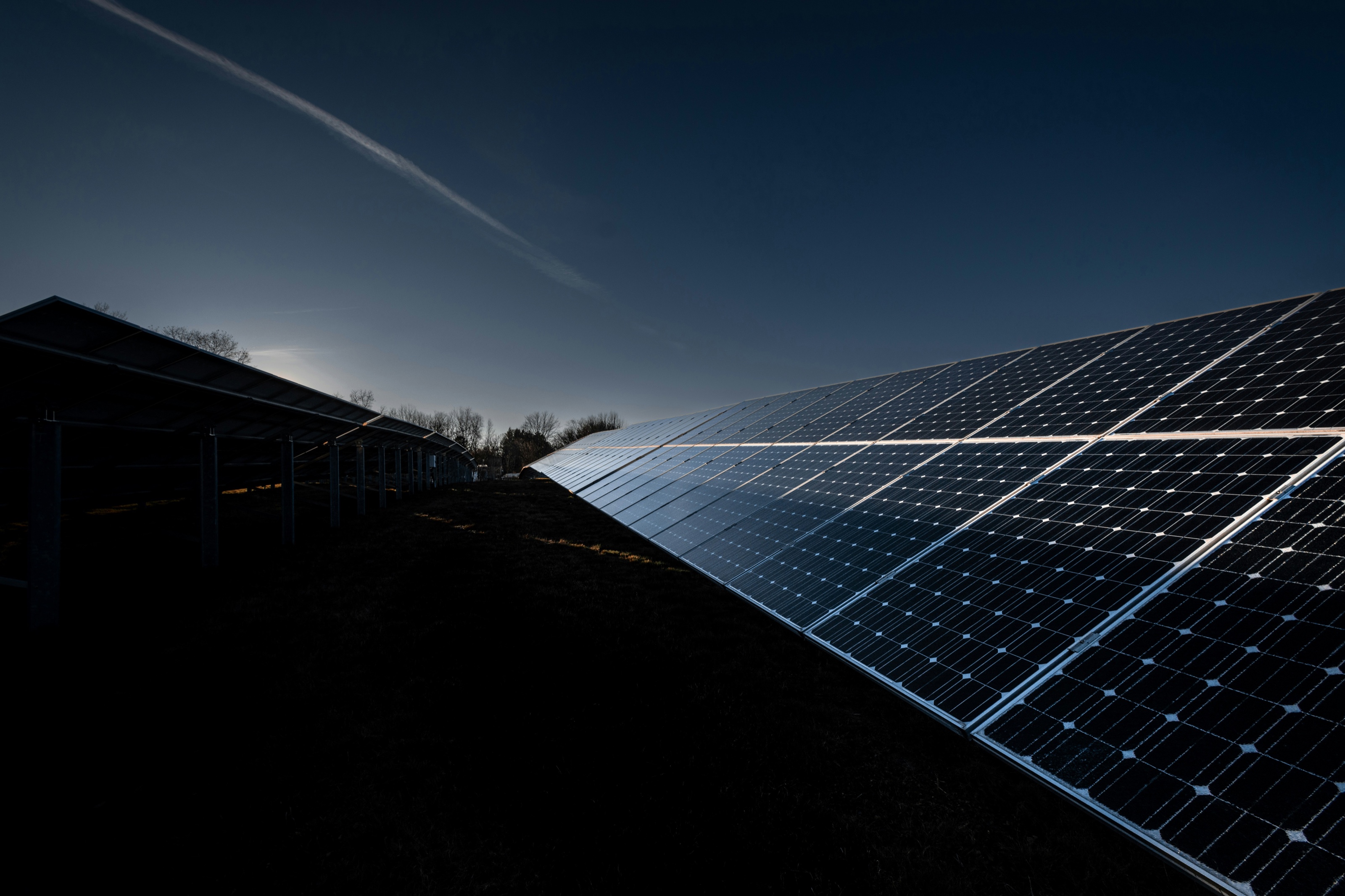 Ground-mounted solar panels lit at dusk