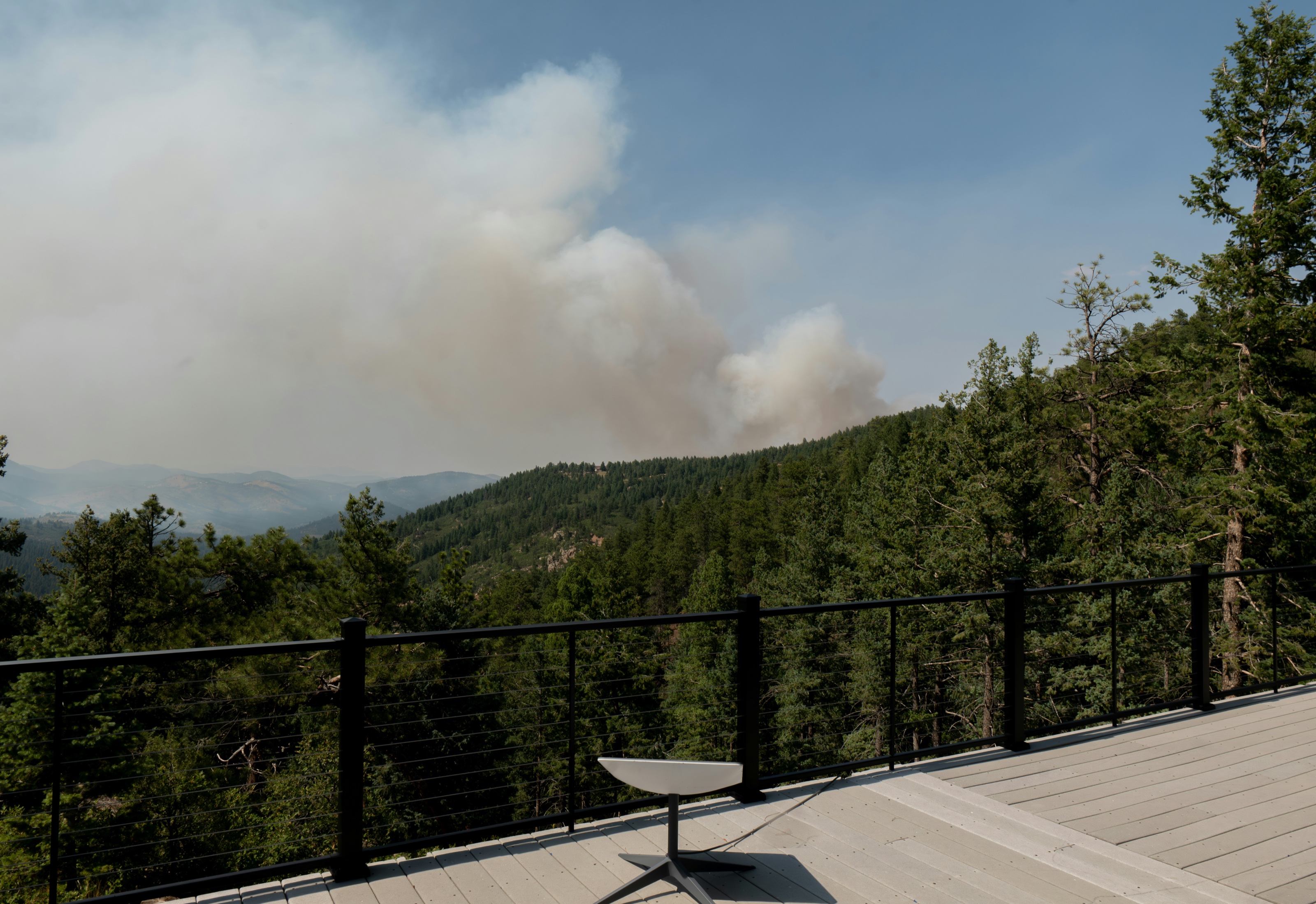 Starlink satellite dish on an elevated deck overlooking a forested valley